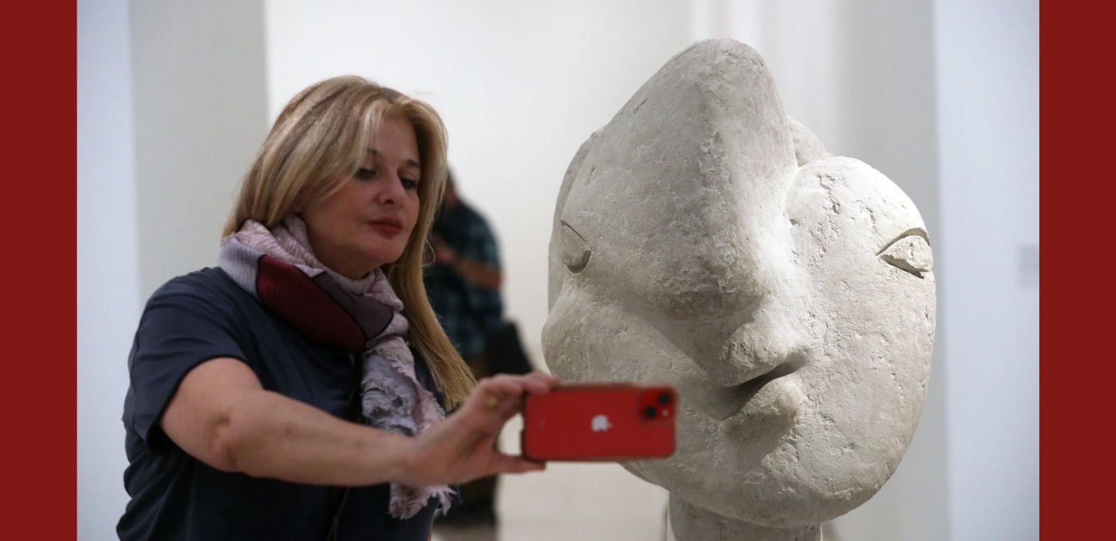 Una visitante se hace un "selfie" junto a una "Cabeza de mujer" (1937) de cemento propiedad del Museo Picasso de Antibes 